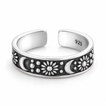 Open sterling silver ring with raised crescent moons, sunbursts and dots on a dark recessed band