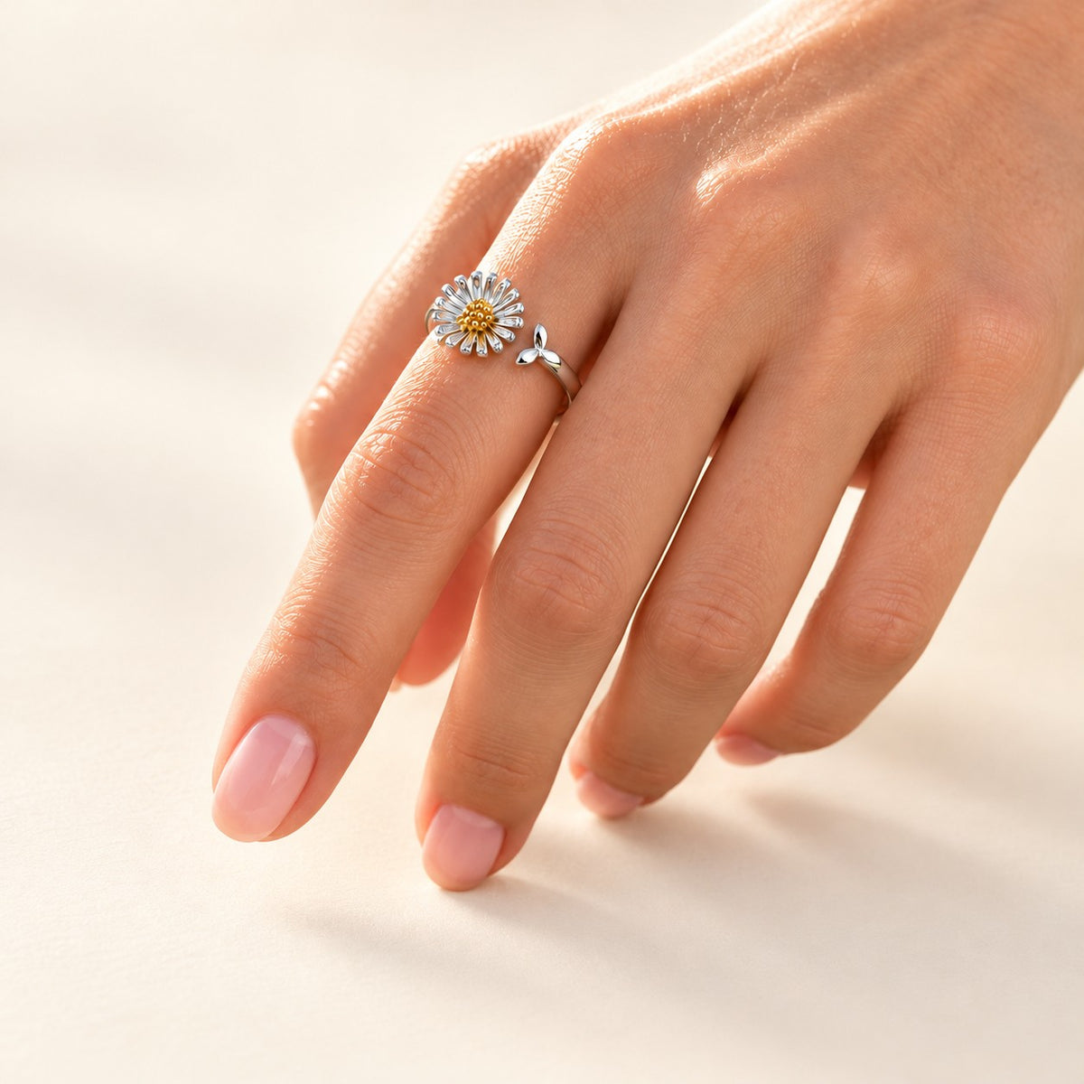 Daisy ring worn on hand, studio photo